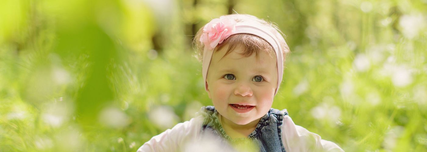 Una niña feliz con un pañuelo en la cabeza corriendo por la pradera 