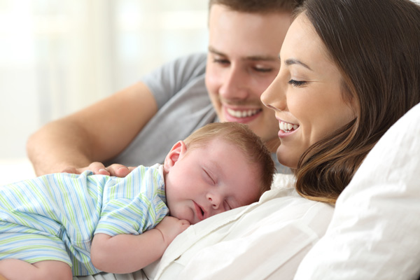 Happy parents with a sleeping baby