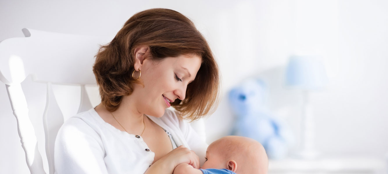 A mother holding her sleeping baby in her arms