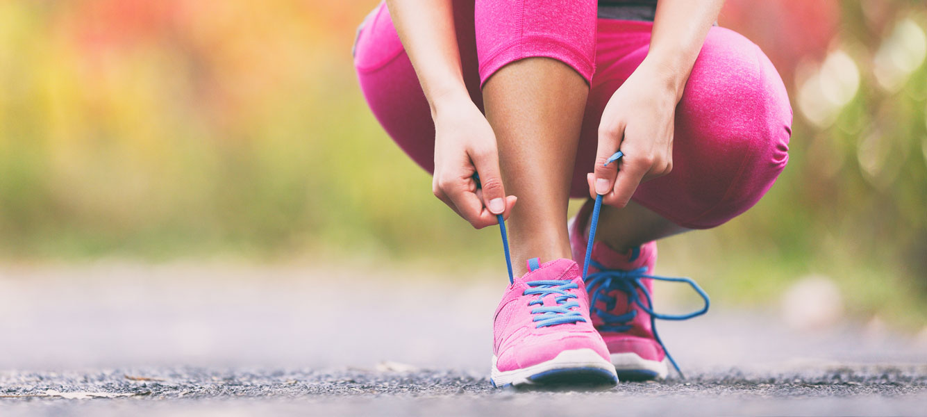 Eine Frau bindet ihre Sportschuhe