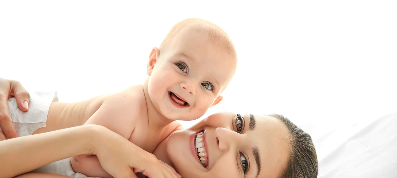 Una madre feliz sostiene a su bebé en sus brazos