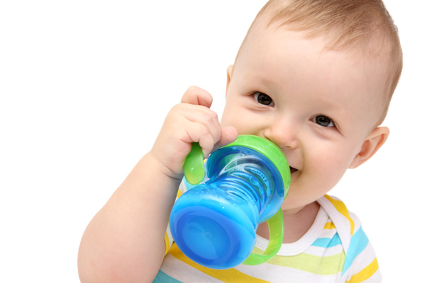 Ein kleiner Junge trinkt aus einem Becher Milch Folgenahrung