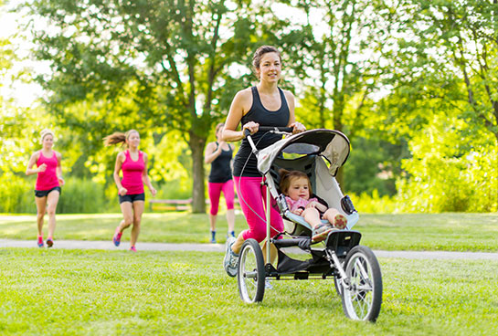 Frau, die mit dem Kinderwagen joggt