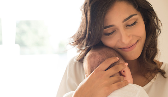 Madre sosteniendo a su bebé en sus brazos