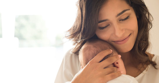 Mother embracing her baby in her arms